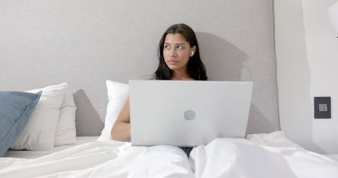 Teenage Girl Using Laptop in Bed for Remote Learning or Leisure