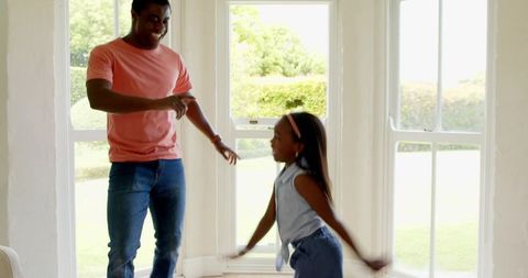 Happy Father and Daughter Dancing Together at Home