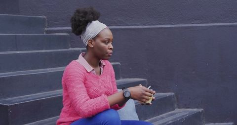 Casual Woman Relaxing with Mug on Urban Steps
