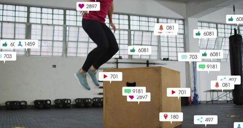Jumping woman performing box jump in gym with social media notification overlays