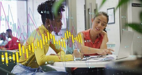 Collaborating on Data and Documents: Two Colleagues Reviewing Laptop in Modern Office