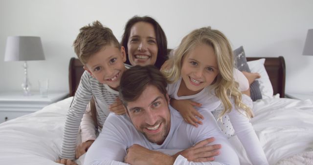 Happy Family of Four Enjoying Time Together in Bedroom - Download Free Stock Images Pikwizard.com