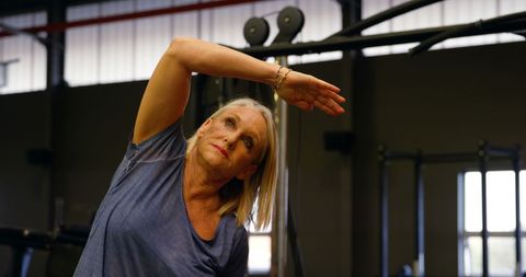 senior woman staying fit stretching in modern gym - Download Free Stock Images Pikwizard.com