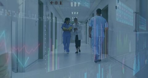 Healthcare team walking corridor reviewing digital health analytics and patient dashboards