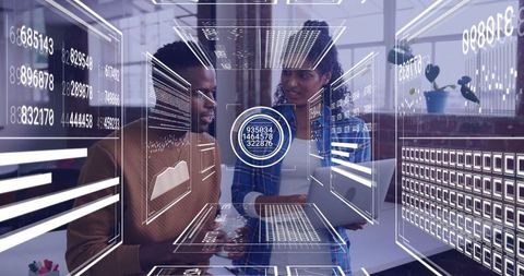 Collaborating analysts examining digital data panels in modern workspace