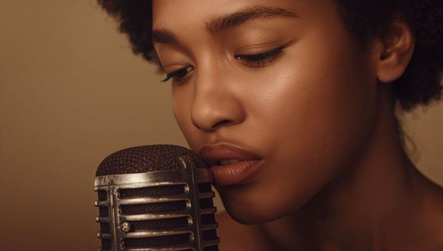 Soulful african american singer leaning into vintage microphone closeup warm portrait