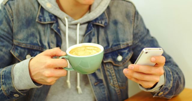 Young Man Drinking Coffee and Using Smartphone in Cafe - Download Free Stock Images Pikwizard.com