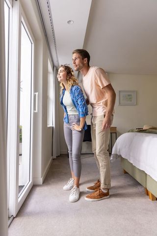 Couple Gazing Through Bedroom Window in Modern Home