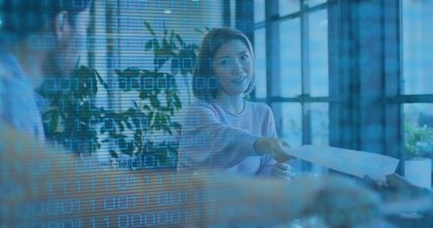 Businesswoman handing document across conference table with digital binary overlay