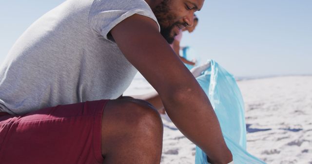 Environmentally Conscious Man Cleaning Beach on Sunny Day - Download Free Stock Images Pikwizard.com