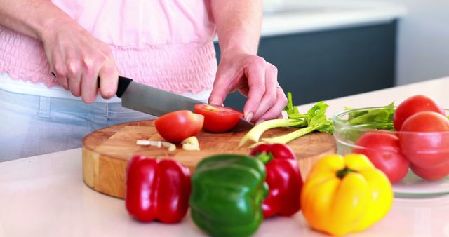 Person Chopping Vegetables in Modern Kitchen with Tomatoes and Bell Peppers - Download Free Stock Images Pikwizard.com
