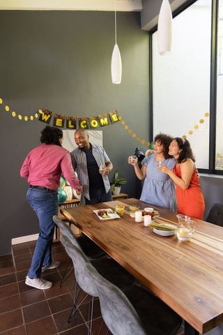 Friends celebrating at home gathering with welcome banner
