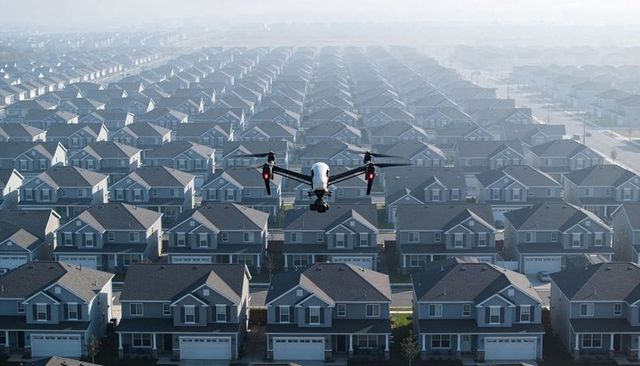 Aerial drone surveying sprawling suburban subdivision at dawn, misty rows and gimbal camera