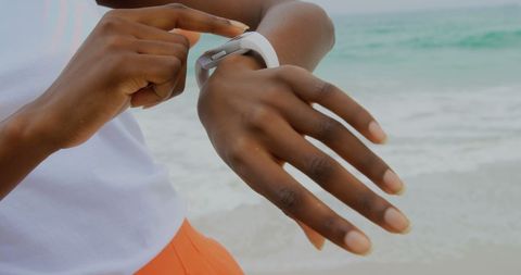 Woman Using Smartwatch on Beach