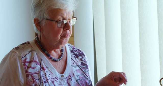 Senior Woman Reading by Window in Natural Light - Download Free Stock Images Pikwizard.com