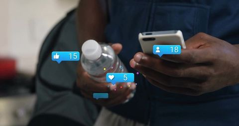 Man scrolling phone while holding water bottle with social media reactions overlay