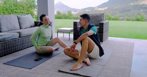 Diverse Group Relaxing on Patio After Workout with Technology