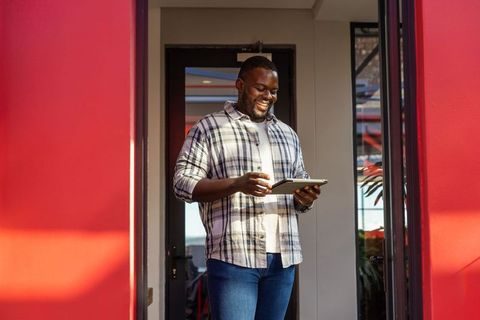 Smiling professional using tablet in colorful modern office lobby