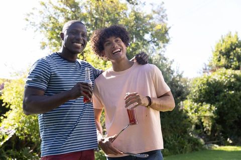 Friends Enjoying Barbecue With Drinks on Sunny Day