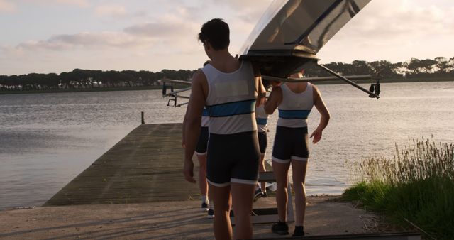 Rowing Team Carrying Boat to Open Water at Sunset - Download Free Stock Images Pikwizard.com