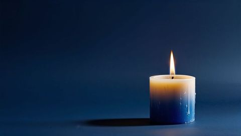 Flickering Candle Flame on Blue Surface Creating Relaxing Ambiance