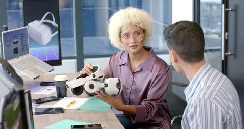 Team discussing virtual reality headset in modern office