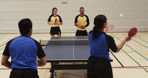 Energetic table tennis doubles team engaged in intense match