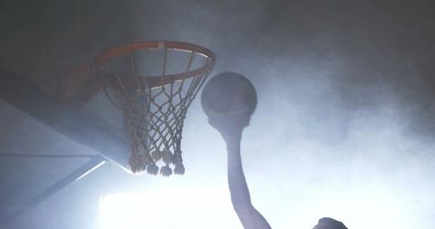 Basketball Player Dunking Silhouette on Smoky Court Background
