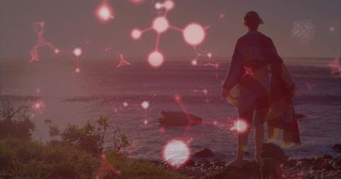 Mystical Woman Shielded From Winds Overlooks Ocean at Sundown