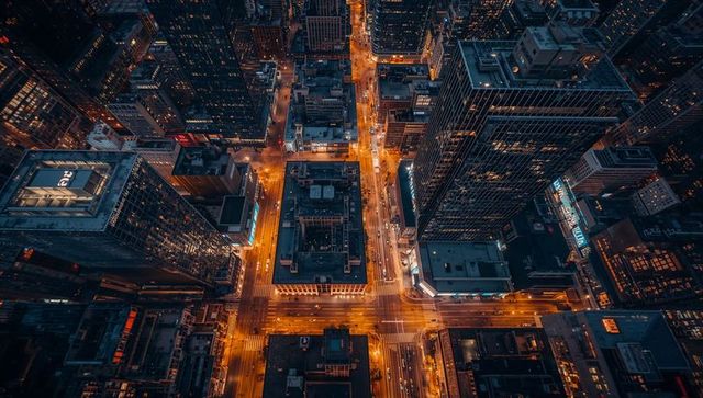 Glowing Urban Grid Showing Lit Four-Way Intersection from Birdseye Night Aerial