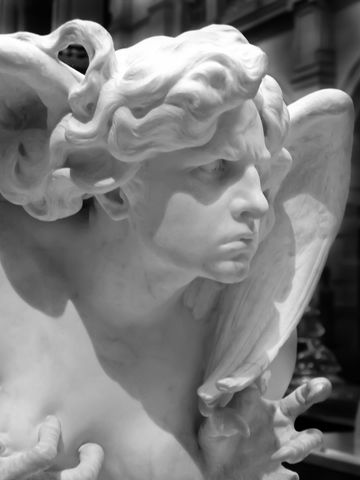 Ornate marble angel statue with intense expression