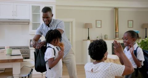 Parents preparing children for first day of school, sharing smiles