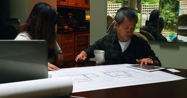Architects Reviewing Blueprints at Home Office with Tablet - Download Free Stock Images Pikwizard.com