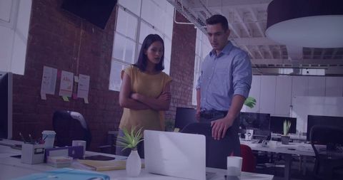 Colleagues analyzing project on laptop in modern office setting