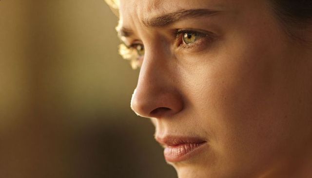 Gazing woman with green hazel eyes golden hour closeup portrait showing skin texture
