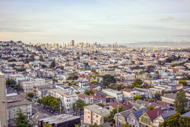 This stock photo captures a stunning sunset view of the San Francisco city skyline and surrounding residential neighborhoods. Ideal for travel websites, blogs about California, real estate brochures, or urban lifestyle articles. Use this visual to convey the essence and beauty of city life in San Francisco.