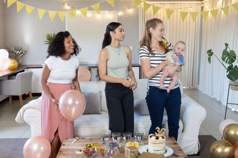 Diverse women celebrating 30th birthday with cake and decorations at home