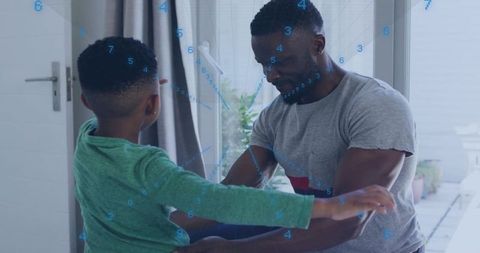 Father kneeling guiding son by sliding door with digital data overlay for smart home care