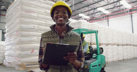 Confident woman in warehouse ensuring inventory accuracy