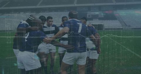 Rugby team huddling on stadium field for tactical discussion