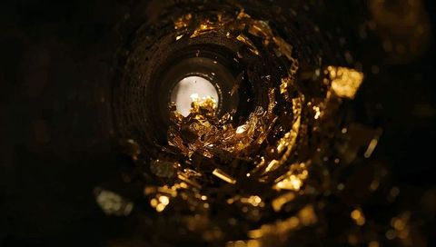 Golden foil tunnel macro with glowing shards, circular opening and reflective bokeh