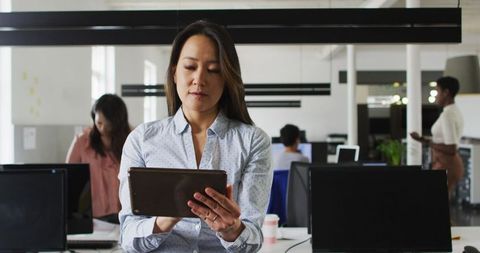 Businesswoman Focusing on Digital Tablet in Modern Office