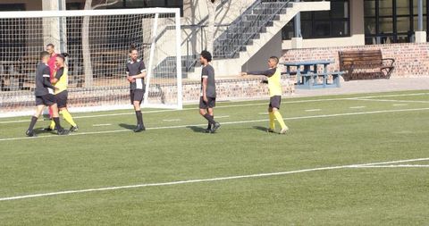 Soccer players discussing strategy near goal during practice
