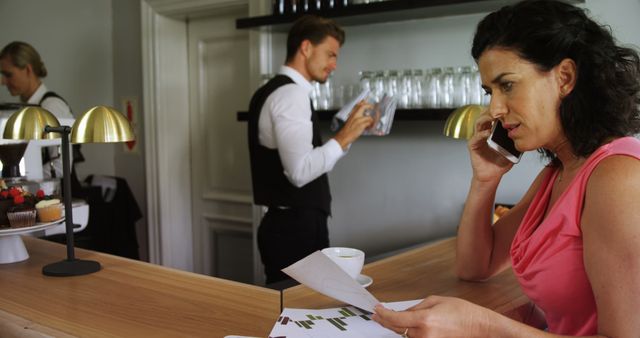 Businesswoman talking on phone in cafe while waiter serves - Download Free Stock Images Pikwizard.com