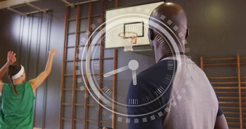 Coach timing player shooting drills on indoor basketball court with stopwatch overlay