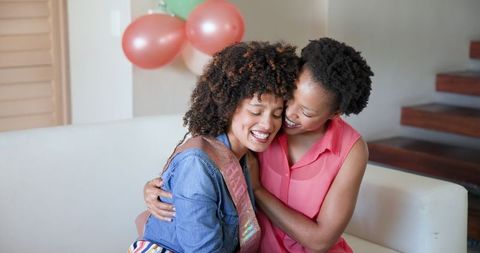 Celebrating Friendship and Laughter in Cozy Living Room Embrace
