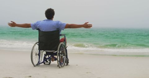 Man in Wheelchair Enjoying Tranquil Beachfront View
