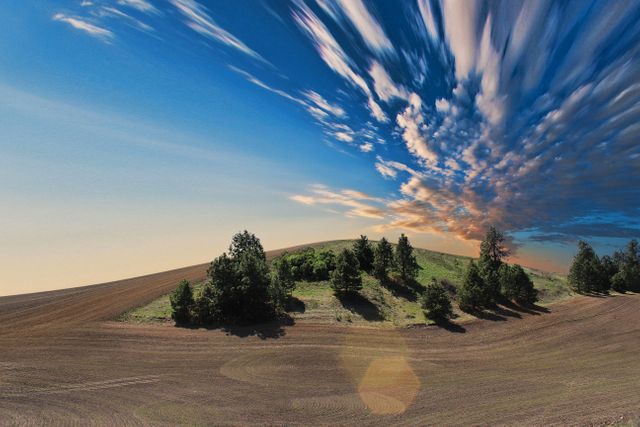 Dynamic Sky Over Rolling Hills and Trees at Sunset - Download Free Stock Photos Pikwizard.com