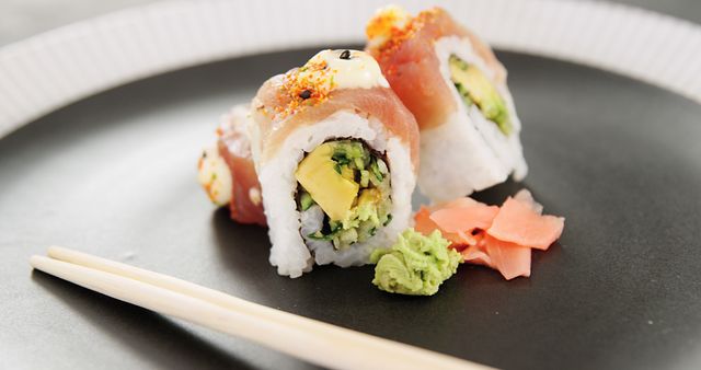 Close-up of Fresh Sushi Rolls with Chopsticks on Plate - Download Free Stock Images Pikwizard.com