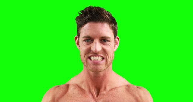 Portrait of angry caucasian strong man lwith copy space on green screen. Strength and fitness concept.